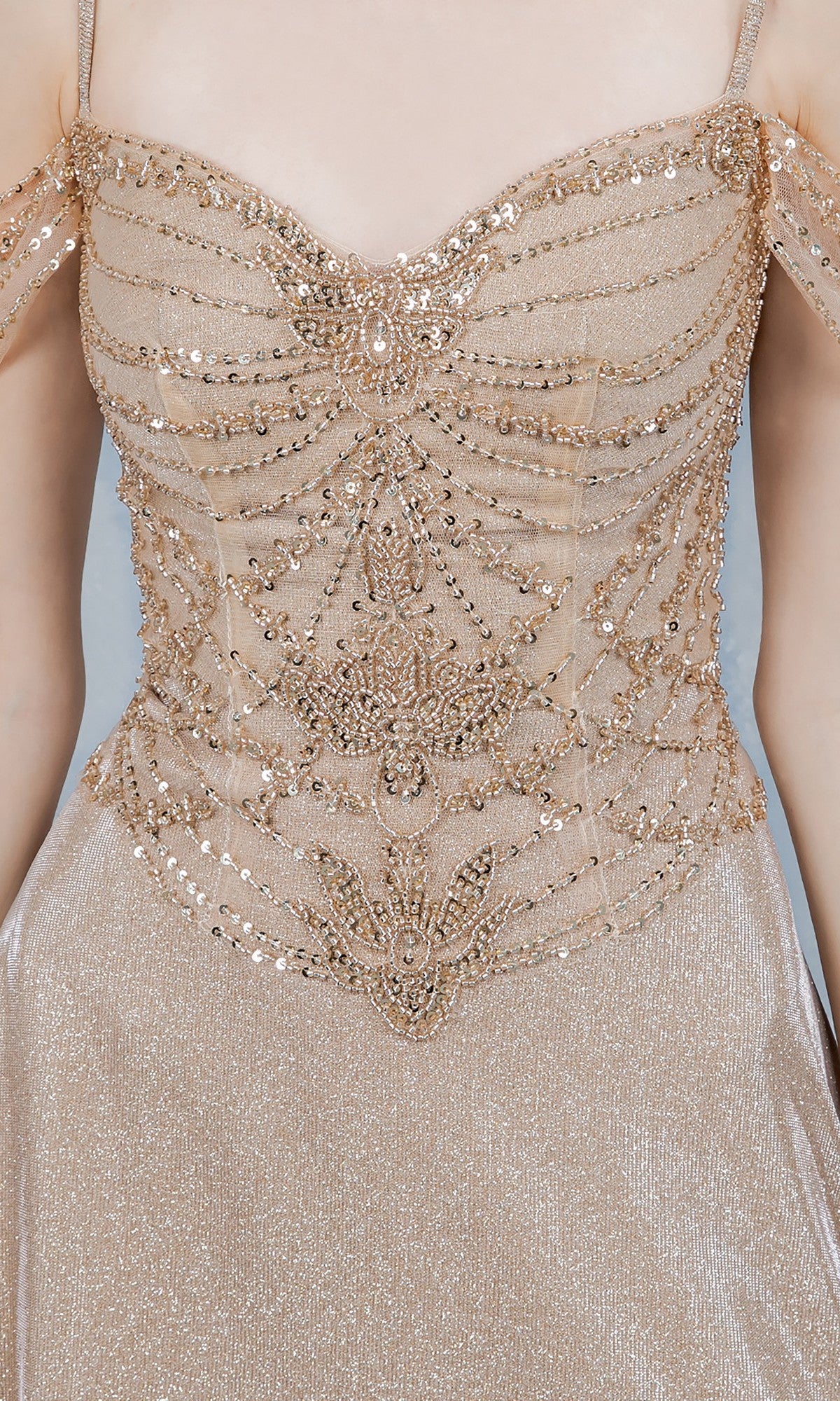 Close-up of a person wearing the Cinderella Couture 8581J long prom dress, featuring a shimmery light gold A-line skirt and a beaded, sequin-adorned bodice.
